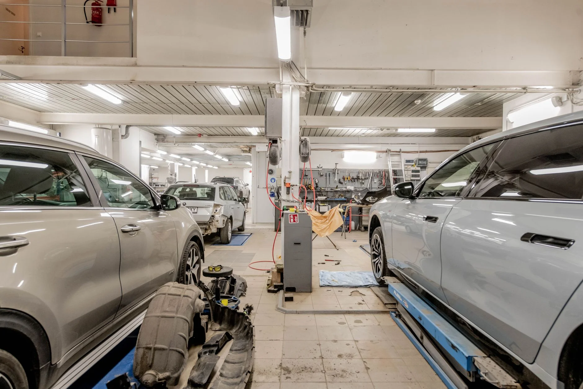 Interior of an automotive repair shop with cars undergoing maintenance and servicing. – Foto: Renee Razumov / Pexels